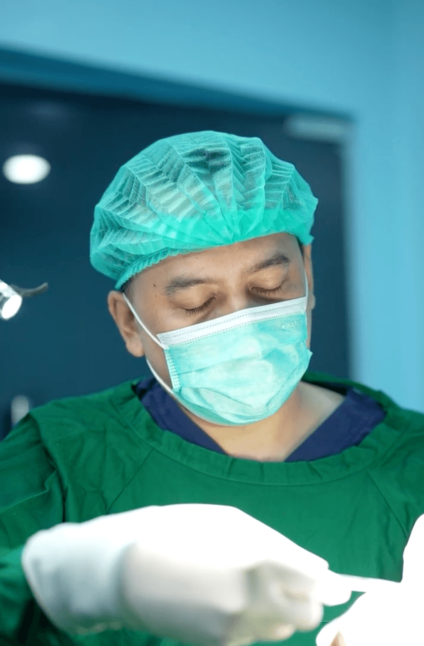 Dr. Danu standing beside an EMFACE aesthetic device in the clinic